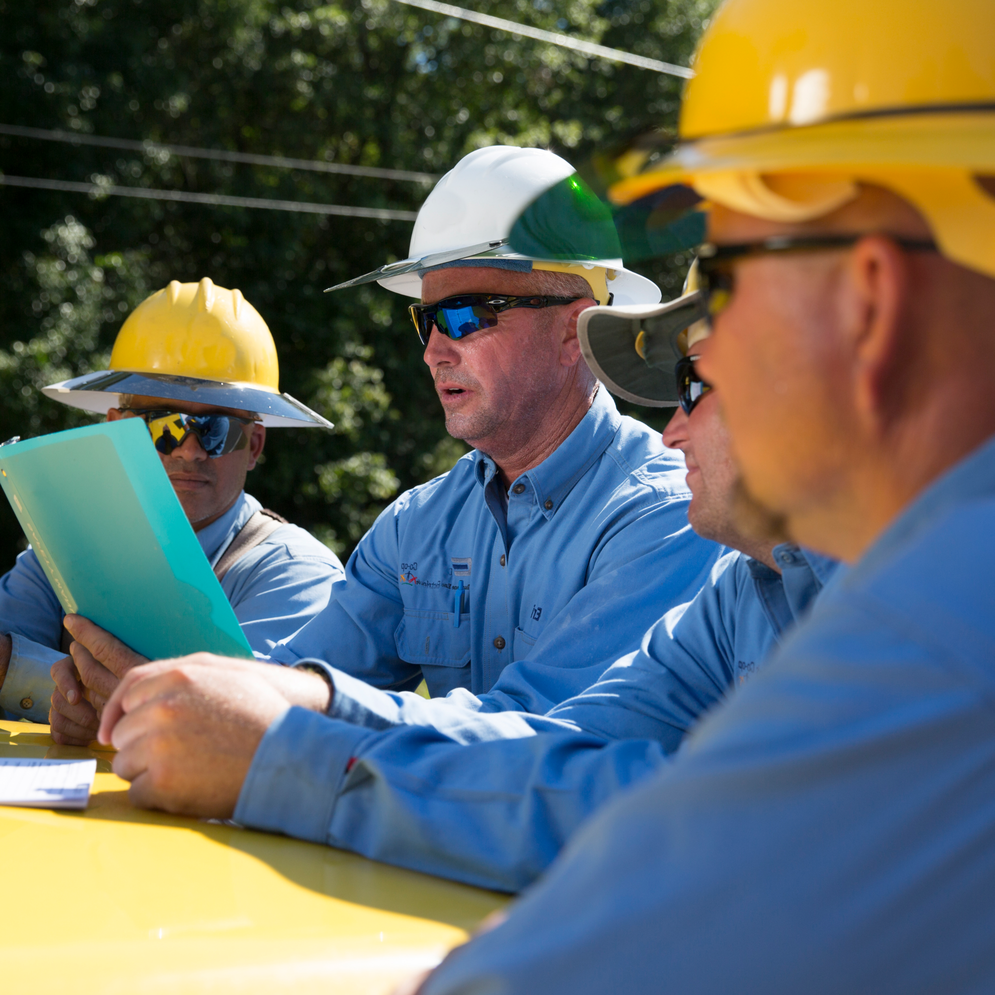 lineworkers in hard hats meeting